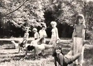 A vintage photo of Girl Scouts at summer camp at the starting line for wheelbarrow races