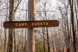 A wooden sign with the text 'Camp Cuesta' carved into it